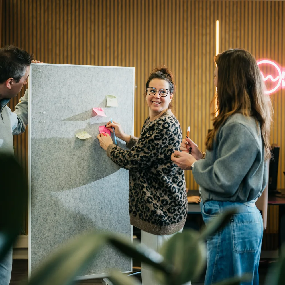 Doorvragen bij het bord met post-its tijdens een strategiesessie