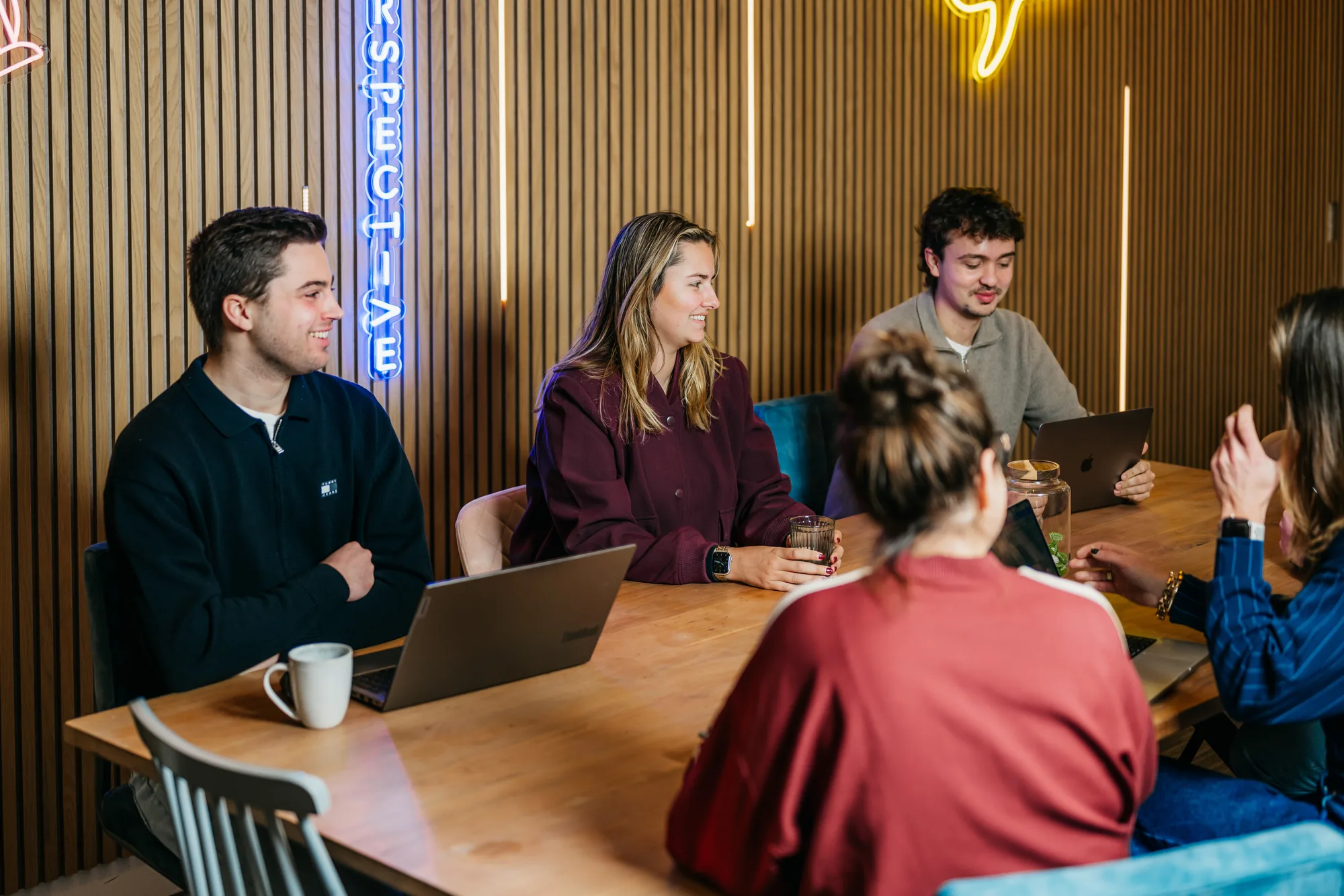 Het team van Milkshake marketing overlegt met laptops aan de grote tafel